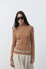 Polera de manga larga y cuello alto, confeccionada en tejido de punto fino, con un ajuste ceñido al cuerpo.