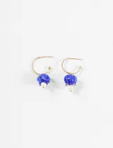 Aros tipo argolla dorados con un dije colgante de vidrio soplado azul en forma de tulipán invertido, con una perla blanca colgando de la base.
