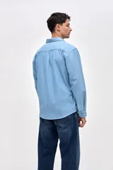 Camisa de corte regular fit confeccionada en algodón, con cuello solapa clásico, cierre frontal de botones y dos bolsillos frontales en el pecho.