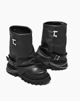 Bota negra de caña media con hebilla lateral y cadena decorativa.