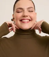 Blusa Ashua de cuello alto y manga larga, confeccionada en viscosa y elastano, de diseño liso y ajuste ceñido.