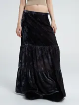 Falda larga de terciopelo negro con textura arrugada y volados en el ruedo.