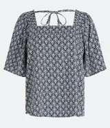 Blusa de manga corta amplia, color azul marino con estampado geométrico en blanco. Presenta escote cuadrado con lazos ajustables en la parte superior de la espalda.