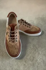 Championes de cuero en tonos marrones y beige combinados, con texturas y detalles pintados a mano por Carolina De Cunto, suela de goma blanca y cordones marrones.