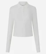 Blusa tipo polo de manga larga confeccionada en algodón, con cuello clásico y cierre frontal de botones. Presenta un diseño de corte regular y acabado suave.