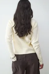 Cardigan de punto gris oscuro, de corte clásico y calce ajustado, con cuello redondo y cierre frontal de botones.