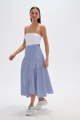 Falda midi de viscosa con estampado de rayas verticales azules y blancas. Presenta un diseño asimétrico con un cruce diagonal en la cintura y un volante fruncido en el ruedo.