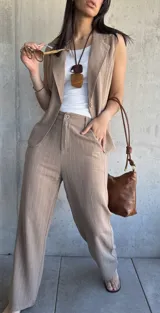 Pantalón de vestir color tostado con finas rayas verticales blancas, de corte palazzo y tiro alto.