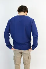 Buzo azul de algodón texturizado con logo bordado en el pecho.