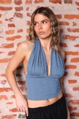 Top de lycra azul con textura calada, corte halter y espalda descubierta.