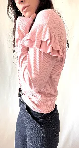Remera de punto color rosa con mangas largas y volados en los hombros.