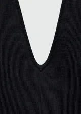 Vestido largo de punto fino color negro, con escote en pico, espalda abierta y tirantes finos. Presenta un diseño entallado con abertura lateral en el bajo.