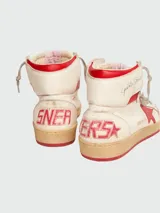 Zapatillas de caña alta Golden Goose modelo Sky-Star, confeccionadas en cuero blanco con efecto desgastado. Presentan una estrella roja en el lateral, detalle de talón rojo y suela de goma con acabado envejecido.