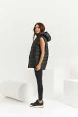 Chaleco negro oversize con capucha forrada en tela gamuzada, cierre metálico YKK, bolsillos laterales y tancas regulables en el ruedo.