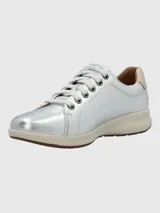 Zapatilla Hush Puppies modelo Spinal de cuero metalizado plateado, con cordones al tono, suela de goma color crema y detalle en el talón. Cuenta con tecnología Spinal para soporte y amortiguación.
