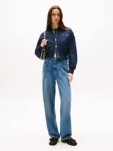 Campera tipo bomber de corte cropped y calce amplio en color azul marino. Cuenta con acabado repelente al agua, aislamiento térmico y relleno ligero. Presenta cuello estilo béisbol, cierre frontal de cremallera, dos bolsillos delanteros ribeteados y terminaciones en punto canalé en cuello, puños y bajo. Incluye el logo de Tommy Hilfiger bordado en el pecho.