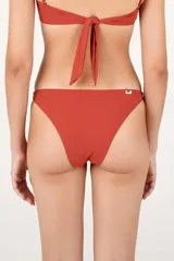 Calzón de bikini de tiro bajo y frente cavado, color rojo, con pretina angosta y bandas laterales anchas de borde curvo.