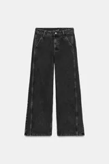 Pantalón de jean negro con lavado gastado, corte culotte, tiro alto, bolsillos delanteros y traseros, y cierre frontal con cremallera y botón.