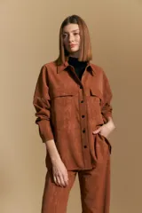 Sobrecamisa de efecto engomado en color negro, con textura lavada, cuello clásico, cierre frontal con botones a tono y bolsillos frontales con solapa.