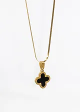 Collar dorado con cadena de eslabones planos y dije de trébol de cuatro hojas con centro negro.