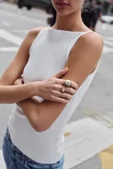 Pack de tres anillos metálicos en tono dorado envejecido, cada uno con una piedra central de forma ovalada en colores amarillo, gris y rosa, con detalles labrados y texturizados en el metal.