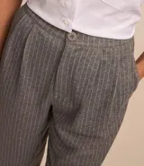 Pantalón jogger de poliéster, viscosa y elastano, con cintura de sastrería, cierre con botón y cremallera, pliegues delanteros, bajo plegado y estampa de raya de tiza.