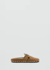 Mocasines destalonados de piel bovina color marrón con tachas metálicas doradas alrededor de la suela y una tira en el empeine con hebilla ajustable.