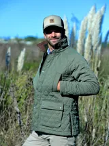 Campera capitoneada de color verde oliva, con cuello de pana marrón, cierre frontal con botones a presión y bolsillos delanteros con solapa.