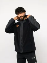 Campera de polar con capucha, cierre frontal completo y diseño en bloques de color azul y azul marino. Presenta detalles en nylon en la zona del cierre y la capucha, con logo de la marca aplicado en el pecho.