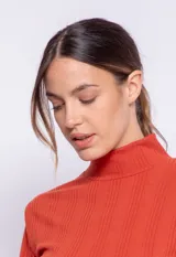 Polera de manga larga y cuello alto, color terracota, con tejido acanalado.