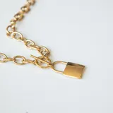 Collar corto dorado con eslabones gruesos y dije de candado.