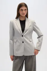 Blazer gris con cuello solapa, bolsillos frontales y cierre con dos botones.