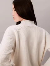 Sweater de punto Calvin Klein color blanco marfil, con diseño acanalado, cuello alto y mangas largas de corte raglán.