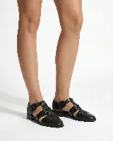 Zapato tipo cangrejera de cuero negro, con diseño de tiras entrelazadas, punta cerrada y pulsera con hebilla ajustable al tobillo. Posee taco bajo cuadrado.