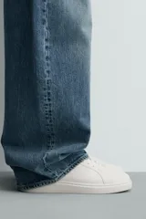 Zapatilla urbana monocolor blanca con cordones al tono, diseño de parte superior lisa, puntera redondeada y suela con volumen.