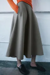 Falda midi de tiro medio con diseño evasé, confeccionada en tejido con viscosa y acabado tipo espiga. Cuenta con cierre de cremallera oculta en el lateral.