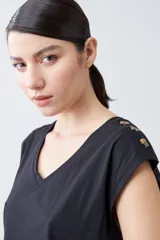 Remera color pistacho con cuello en V y botones decorativos en los hombros.