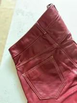 Pantalón slouchy de cuero ovino italiano color burdeos, corte mom fit con tiro semi alto, tajos inferiores y bolsillos laterales.