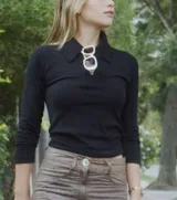 Remera de manga larga con cuello polo, confeccionada en tejido de punto suave y ajustado al cuerpo.