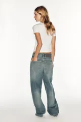 Jeans de tiro medio y corte baggy oversize con diseño de costuras marcadas en las piernas, trabillas para cinturón y cinco bolsillos tradicionales. Cierre frontal con cremallera y botón metálico.
