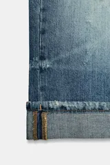 Bermuda de jean estilo jorts de tiro medio, con efecto lavado, cinco bolsillos, detalles de roturas y bajo con vuelta.