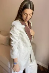 Blazer azul de lino con corte entallado, cuello y solapas combinadas en color gris, cierre con botón de nácar, bolsillos laterales y tajo en la espalda.