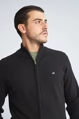 Campera tejida de algodón con cierre frontal completo, cuello alto y mangas largas. Presenta un diseño básico con logo bordado en el pecho.