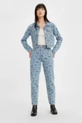Pantalón de jean estilo mom, de tiro alto, con estampado floral en tonos azules y rosados sobre base celeste.