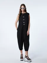 Mono negro de corte baggy, musculosa con botones delanteros anacarados y puño del pantalón con elástico.