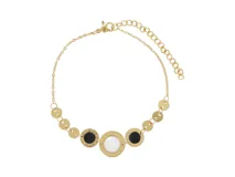 Pulsera dorada de acero con tres dijes redondos: dos con ónix negro y uno con nácar blanco. Tiene cierre de mosquetón y cadena de alargue.