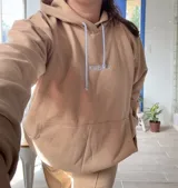 Canguro deportivo de tela suave con logo bordado, diseño holgado y mangas largas.