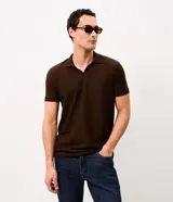 Remera polo de hombre en color marrón, confeccionada en tejido texturizado con mezcla de algodón y poliéster, de manga corta y cuello abierto sin botones.