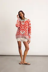 Buzo oversize de punto de algodón con diseño jacquard geométrico en colores coral y celeste, de manga larga y cuello redondo a la base.