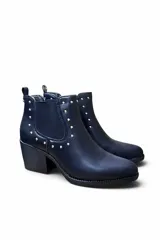 Bota corta de cuero color marrón, con taco cuadrado y elástico lateral. Presenta detalles de tachas metálicas plateadas en el contorno superior y el talón.